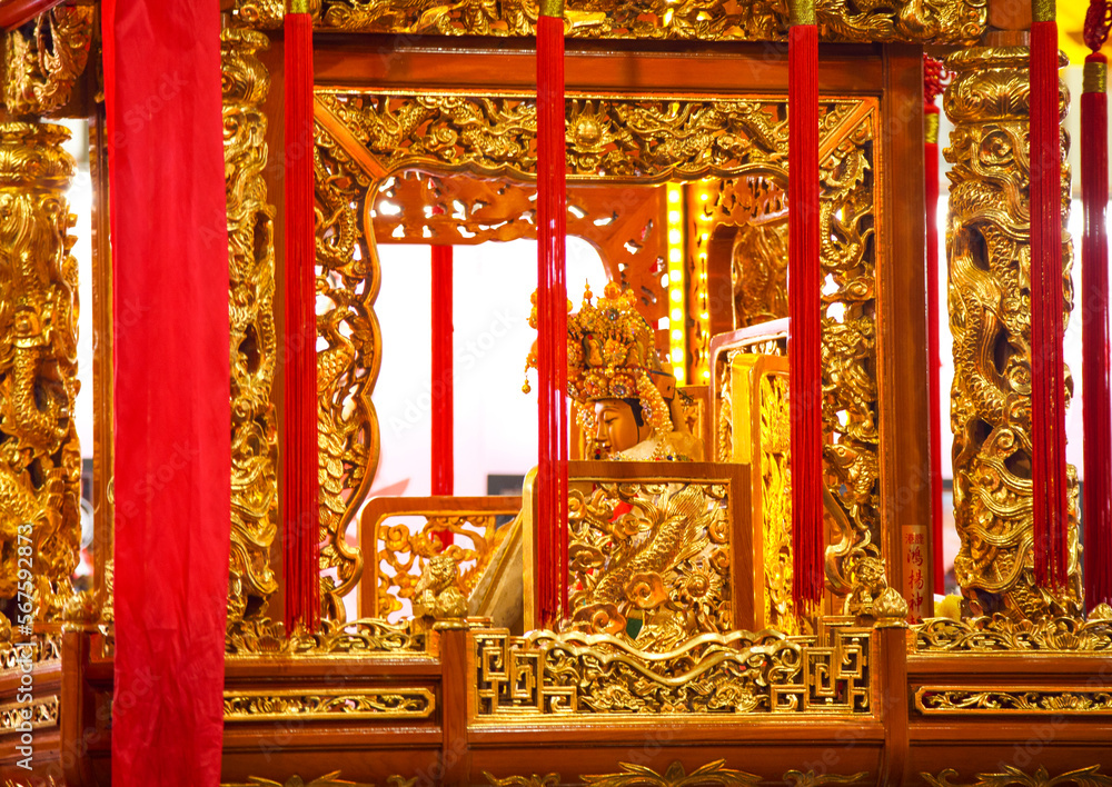 close-up of a gold god statue on a sedan chair