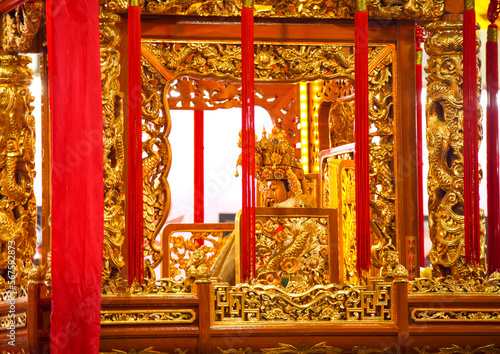 close-up of a gold god statue on a sedan chair