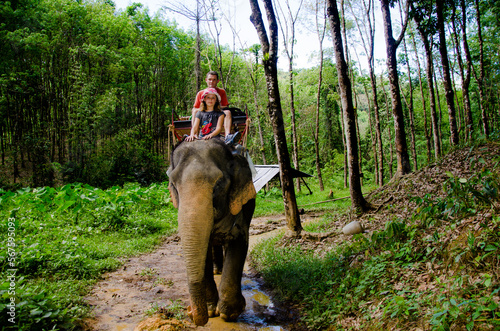 Canvas Print Pretty young girl and her dad doing an elephant trek in Khao Sok National Park i