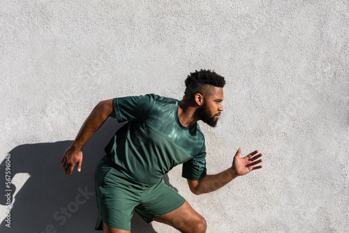 Black young male athlete focused on running for an outdoor summer workout © Michael Cannon