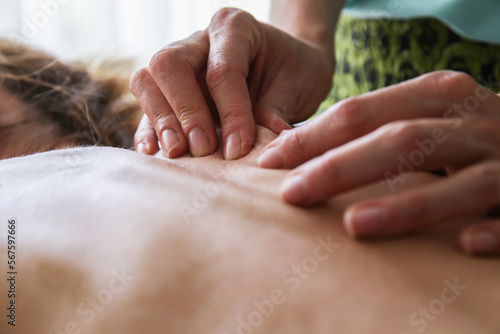 Physiotherapist massaging female patient with injured back muscle. Sports injury treatment. Health, body care, medicine concept. Copy space.
