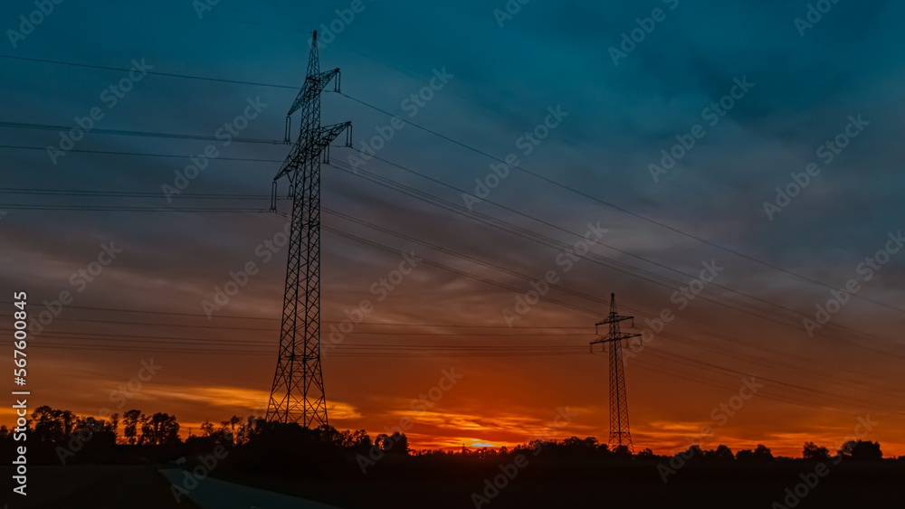 Fototapeta premium Beautiful sunset with a dramatic sky and overland high voltage lines near Tabertshausen, Bavaria, Germany