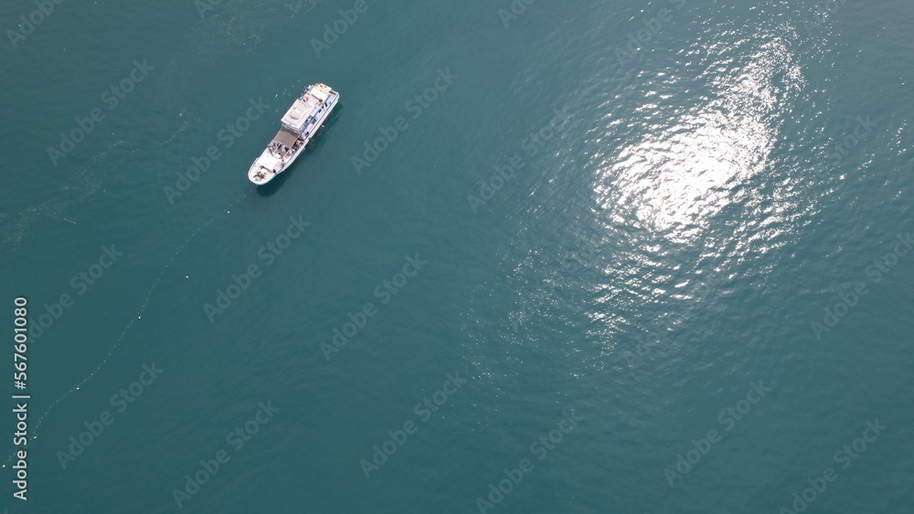 Naklejka premium aerial view of a fishing boat catches fish using nets in the middle of the ocean