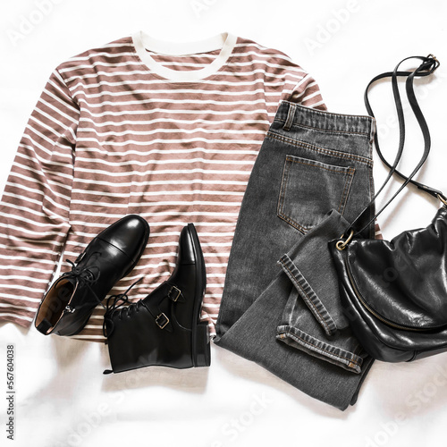 Grey moms jeans, black leather shoes, black leather bag, long sleeve striped t-shirt - women's casual clothing on a light background, top view. Fashion concept