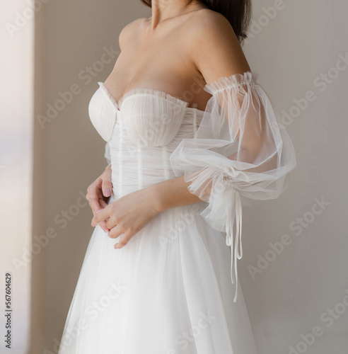 Print op canvas Beautiful brunet bride dressed in the white long wedding dress with the deep neckline