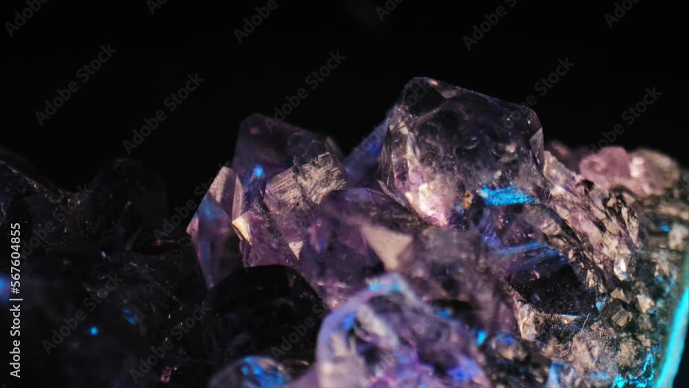 Luminous purple amethyst crystal with color-changing lighting against black background. Smooth panning and macro lens for exquisite details. Luminous purple amethyst crystal with color-changing lighting against black background. Smooth panning and macro lens for exquisite details.