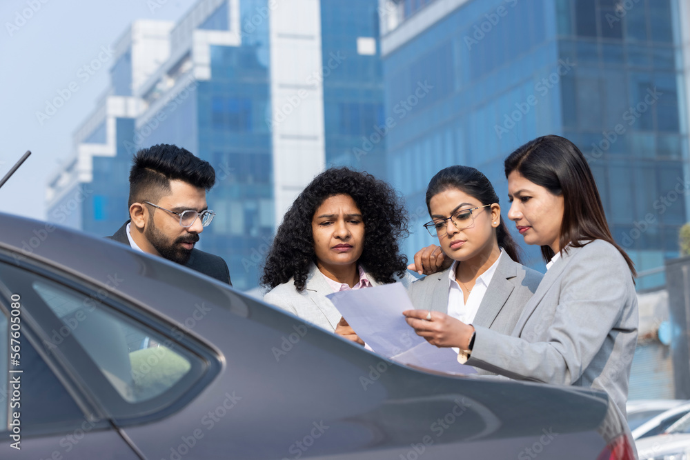 Group of businesspeople going through a report at work Group of businesspeople going through a report at work