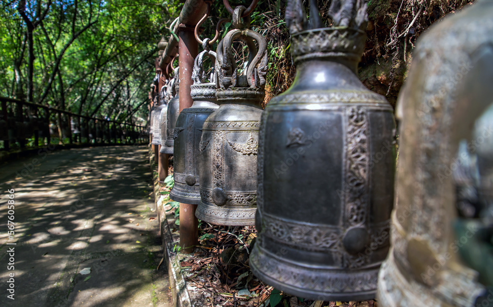 Many metallic bells hanging in a row on wooden pillars outside in thai buddhist temple. Lined with many beautiful bells, Thai temple bell which believe that who knock this bell will get the good luck, Many metallic bells hanging in a row on wooden pillars outside in thai buddhist temple. Lined with many beautiful bells, Thai temple bell which believe that who knock this bell will get the good luck,