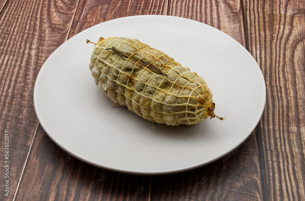 Roast turkey in a white dish on wooden table