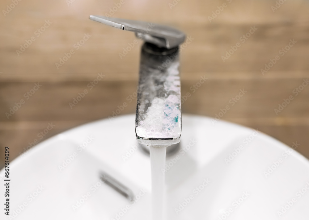 Limescale on metal chrome faucet, tap with running water of bad quality Limescale on metal chrome faucet, tap with running water of bad quality