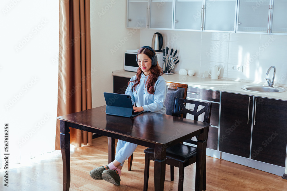 Smiling freelance asian woman working at home