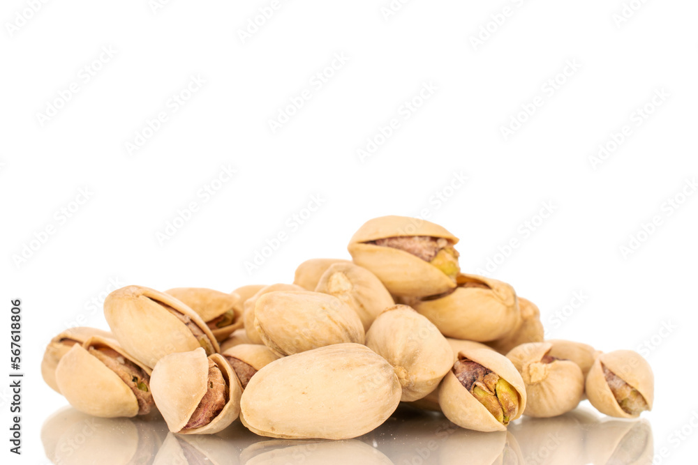 Fototapeta premium Several unpeeled pistachios, close-up, isolated on white.