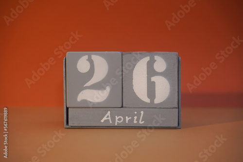26 April on wooden grey cubes. Calendar cube date 26 April. Concept of date. Copy space for text or event. Educational cubes. Wood blocks in box with date. Selective focus blurred background