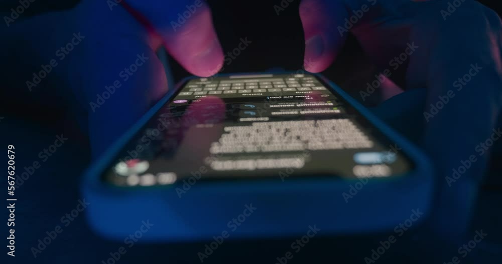 Close-up of male hands holding phone, texting message on a mobile phone at night. Close-up man holds a mobile phone, chats in social network, writes a text message app using mobile phone touch screen