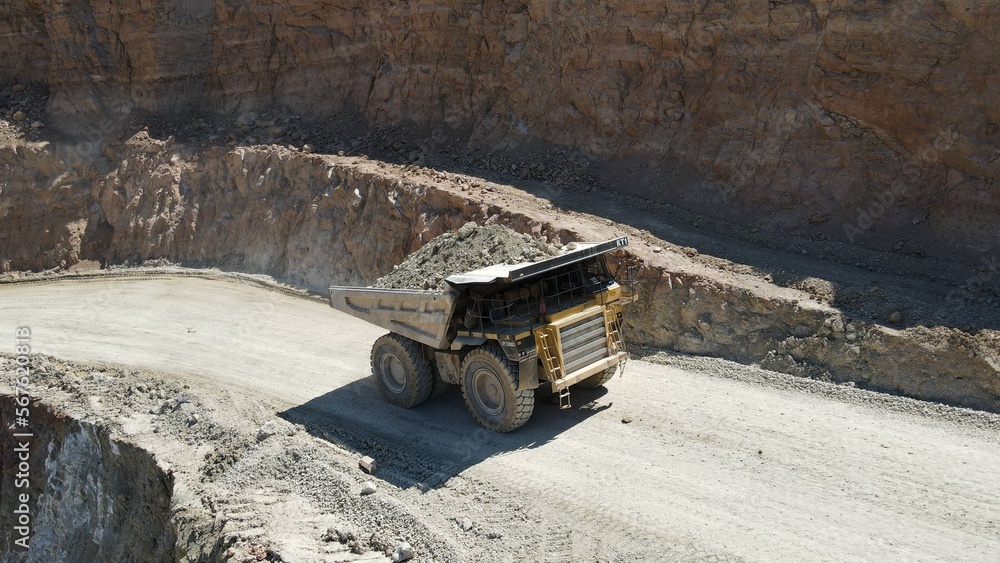 Large quarry dump truck full of stones. Transporting the ore into the crusher. Mining truck mining machinery, transport the material for production.