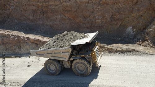 Large quarry dump truck full of stones. Transporting the ore into the crusher. Mining truck mining machinery, transport the material for production.