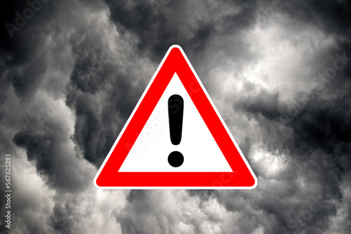 Achtung-Warnschild oder Verkehrsschild vor dramatischen, grauen Wolkenhimmel, als Symbol für Unwettergefahr