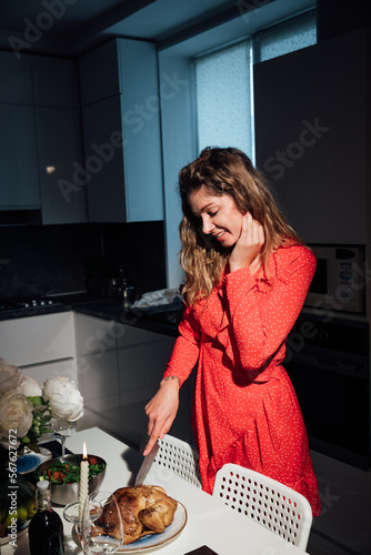 a woman in red clothes cuts a chicken for dinner