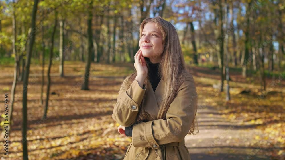 Side view of cheerful, glad woman enjoying sunny autumn weather in park. Beautiful lady wearing elegant clothes, admiring, smiling, enjoying. Concept of harmony with nature. Side view of cheerful, glad woman enjoying sunny autumn weather in park. Beautiful lady wearing elegant clothes, admiring, smiling, enjoying. Concept of harmony with nature.