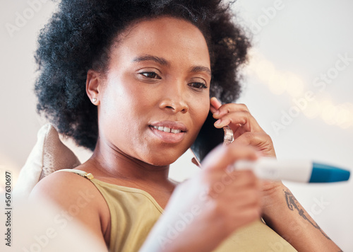 Black woman, pregnancy test and phone call on sofa for good news, announcement and surprised. Pregnant, female and home testing kit for positive, results or sharing ivf success on call in living room