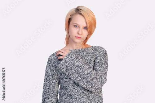 girl teenager in a sweater looks into the frame isolated on a white background © Evgeny