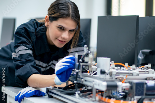 female engineer working on industrial machine in a laboratory.