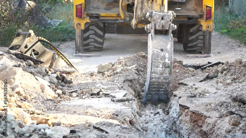 Excavator digs a trench to lay pipes. Close up of an excavator digging a deep trench. An excavator digs a trench in the countryside to lay a water pipe. Slow motion Excavator digs a trench to lay pipes. Close up of an excavator digging a deep trench. An excavator digs a trench in the countryside to lay a water pipe. Slow motion