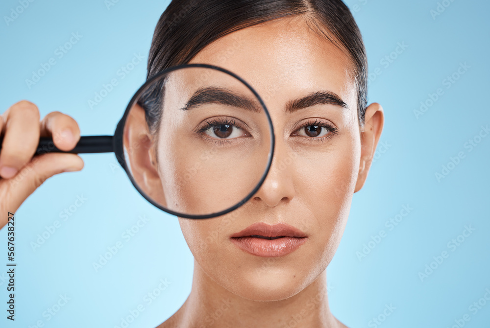 Woman, face with magnifying glass, eyes and beauty in portrait, eye care and vision isolated on blue background. Skincare cosmetics, skin and facial inspection, mockup space and dermatology in studio Woman, face with magnifying glass, eyes and beauty in portrait, eye care and vision isolated on blue background. Skincare cosmetics, skin and facial inspection, mockup space and dermatology in studio