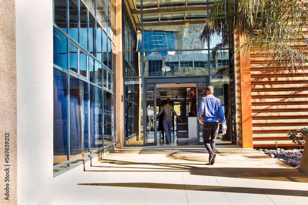 Fototapeta premium two african people walking into a modern building