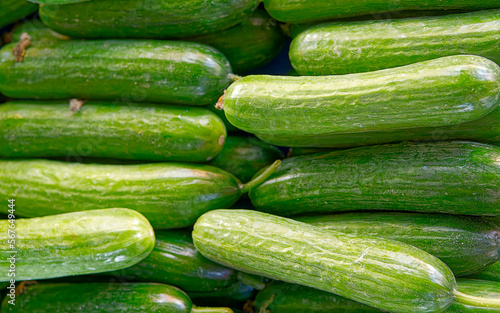 Organic green cucumbers top view close up, fresh vegan food background.