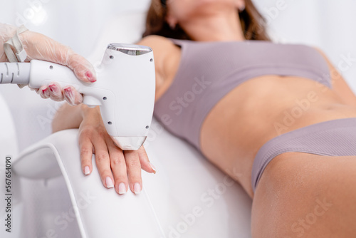 Professional beautician removes hair on beautiful female fingers using a laser. hair removal on the hand, laser procedure at clinic