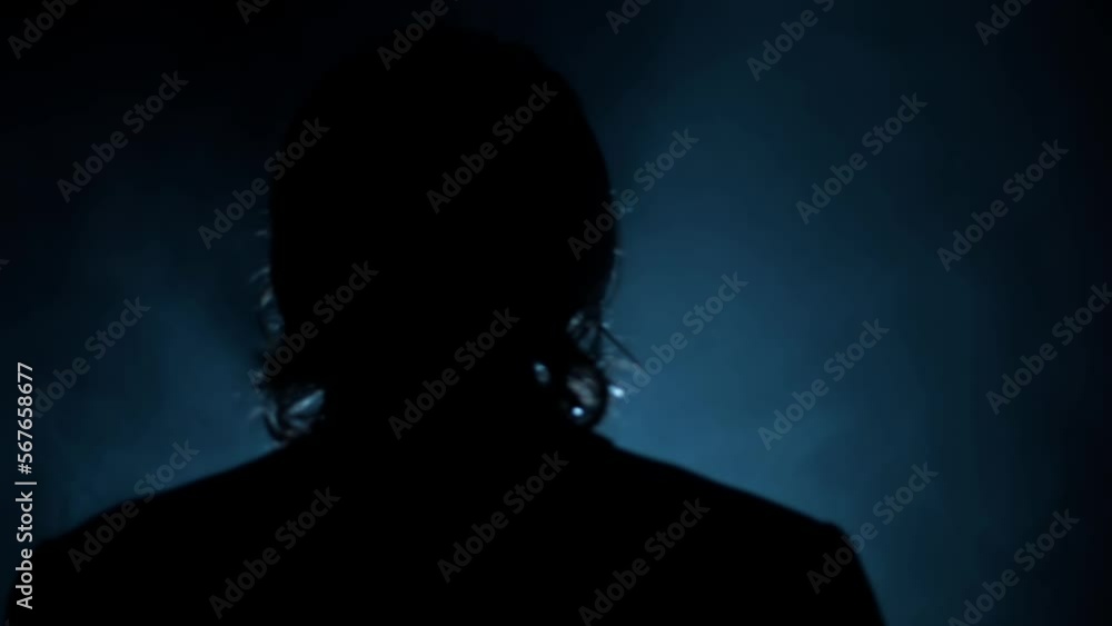 Back side shot of a man with long hair wearing a coat and posing like a movie character, dramatic light and some fog element in it. Back side shot of a man with long hair wearing a coat and posing like a movie character, dramatic light and some fog element in it.