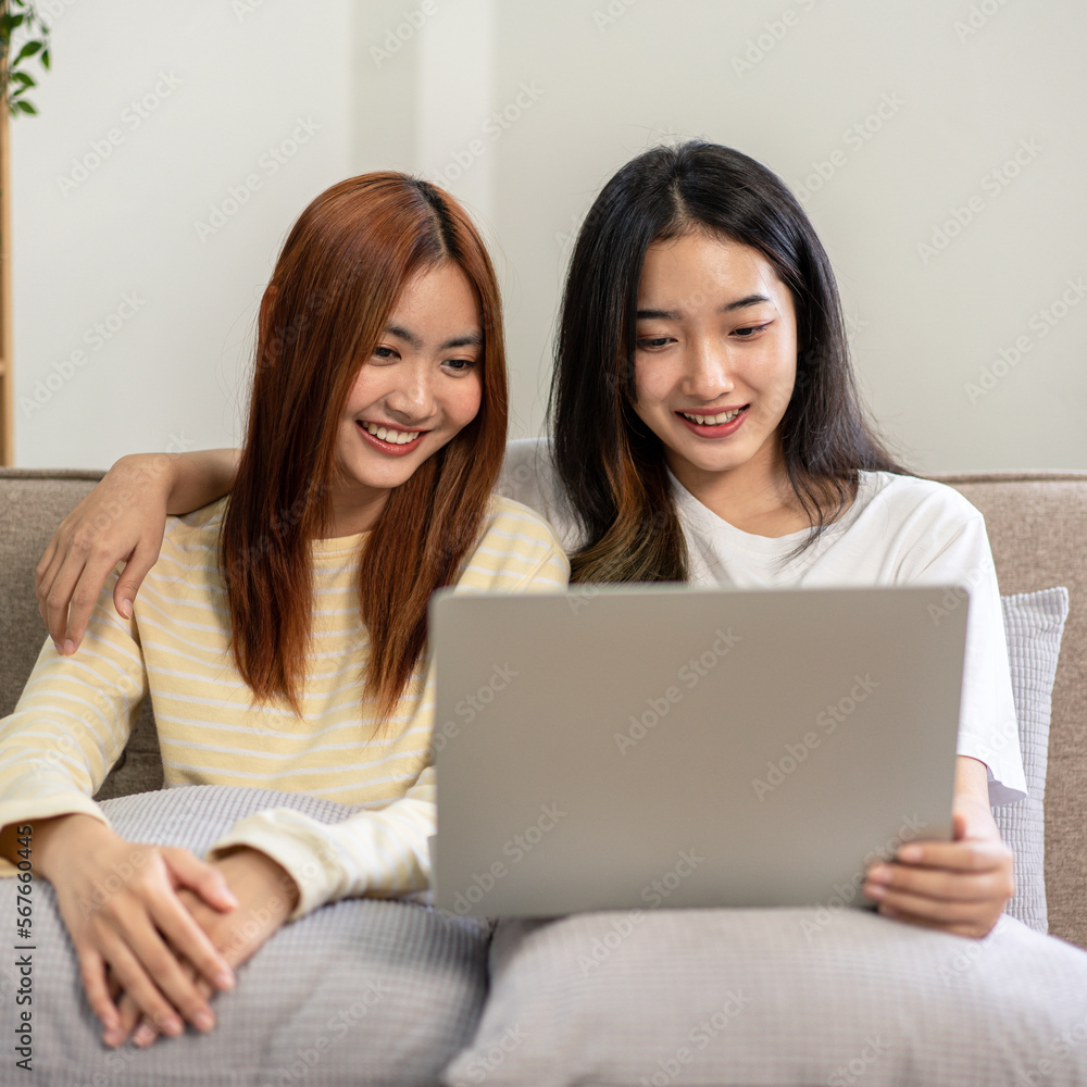 Young woman lesbian couple sitting to embracing and watching mov Young woman lesbian couple sitting to embracing and watching mov