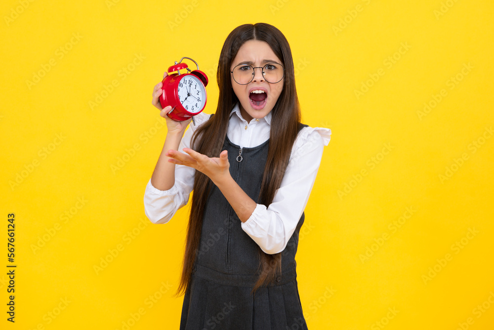 Fototapeta premium Punctual teen girl checking time. Child with alarm clock showing time. Angry teenager girl, upset and unhappy negative emotion.