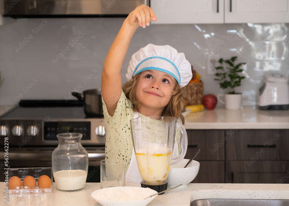 Kid chef cook in chef hat preparing food on kitchen. Child making tasty delicious. Cooking meal. Kid chef cook in chef hat preparing food on kitchen. Child making tasty delicious. Cooking meal.