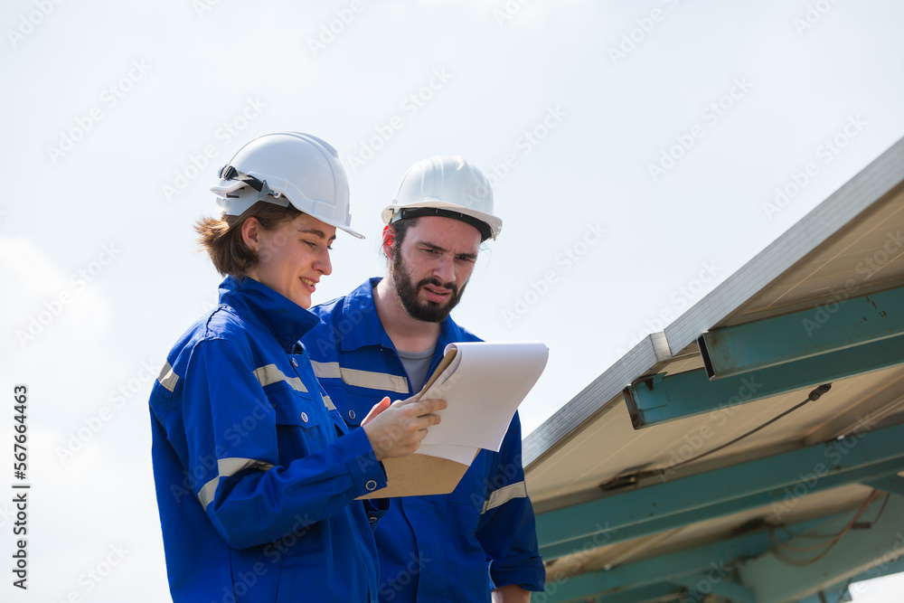 Male and female engineer worker working on forklift truck working checking or maintenance solar panels power farm Male and female engineer worker working on forklift truck working checking or maintenance solar panels power farm