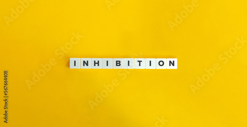 INHIBITION Word on Block Letter Tiles on Yellow Background. Minimal Aesthetics.