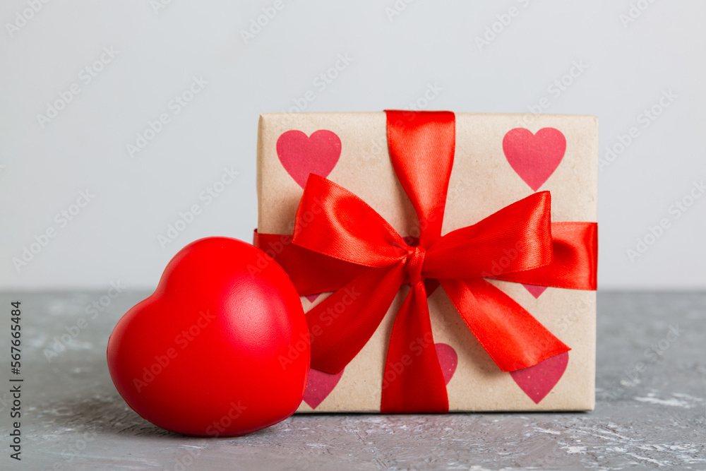 gift box with red bow and red heart on colored background. Perspective view. Flat lay gift box with red bow and red heart on colored background. Perspective view. Flat lay