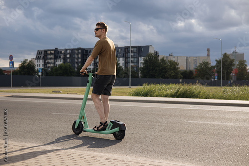 Sustainable Mobility Young Man Unlocks the Future of City Transportation with an Electric Scooter and Mobile Phone. The Key to Achieving Green and Climate Neutral Cities