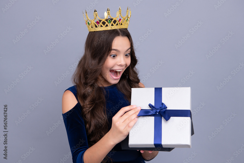 Child with gift present box on isolated studio background. Gifting for kids birthday. Excited teenager girl. Child with gift present box on isolated studio background. Gifting for kids birthday. Excited teenager girl.