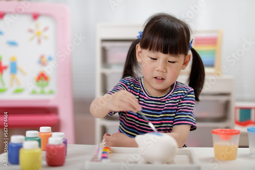 young girl decorating hand made craft for homeschooling