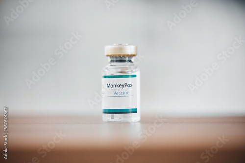 Moneypox, hospital vaccine and bottle for healthcare, medical virus and cure for disease on a table. Health, care and vial of liquid for a vaccination, pandemic remedy and prevention at a clinic photo