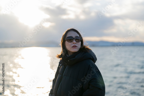 夕暮れの海でサングラスをしている女性 © peach100