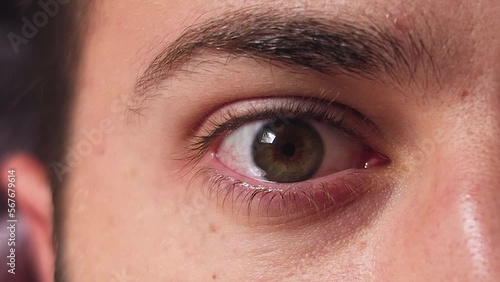 Close-up of a man with green eyes sleeping and waking up.