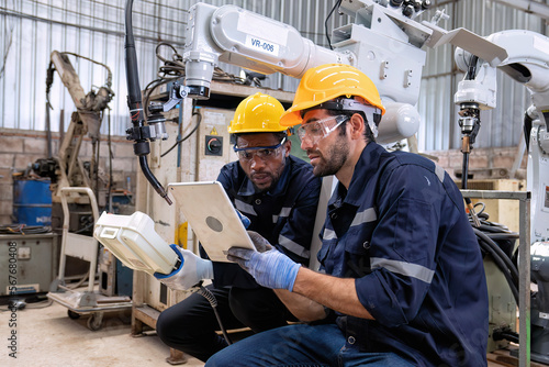 Maintenance engineer repair and programing robotic arm in factory Industry robot service shop