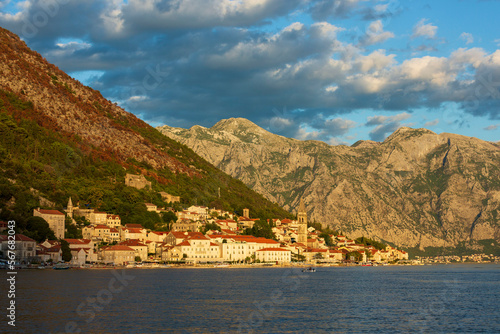 Seaside town in the rays of the setting sun against the backdrop of majestic mountains. Bay of Kotor, Montenegro © Tsapenko_ev