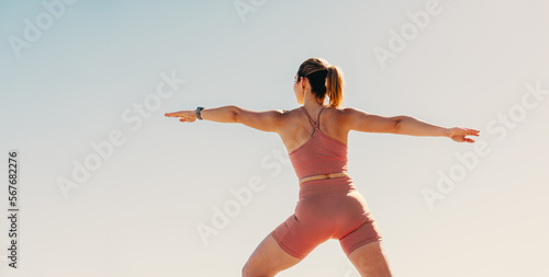 Konstfotografi Woman practicing warrior pose outdoors in sportswear for physical fitness, wellb