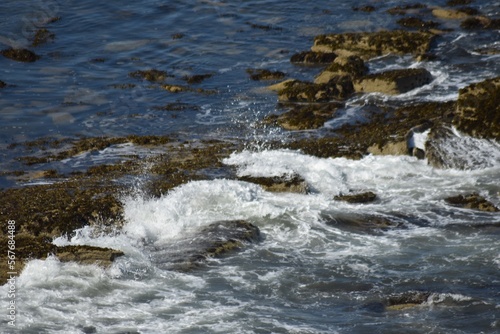 Aerial view looking down onto waves crashing onto rocks. North Berwick Scotland. 