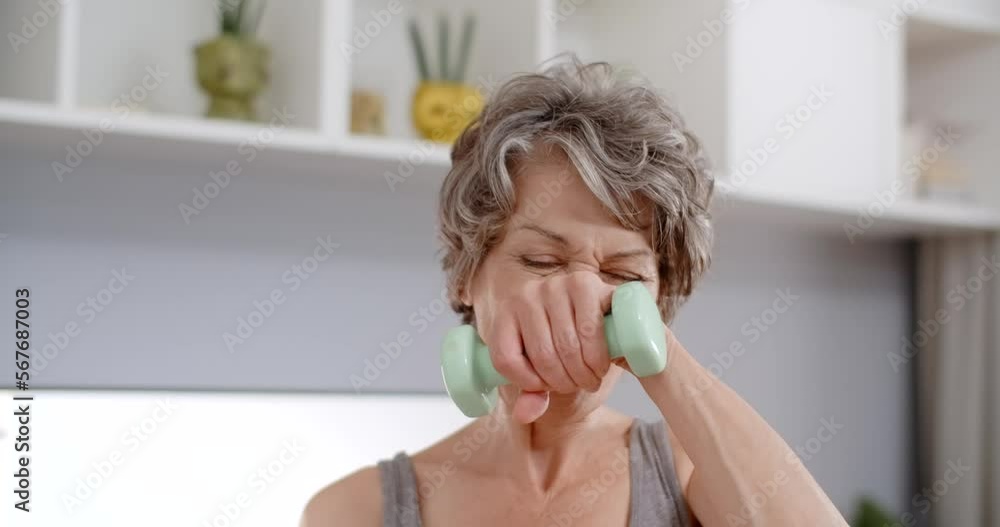 Portrait of elderly lady doing energizing dumbbell exercises at home, fitness training for seniors, 4k Portrait of elderly lady doing energizing dumbbell exercises at home, fitness training for seniors, 4k