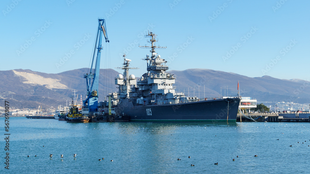 Cruiser Mikhail Kutuzov is museum ship. Close-up. Warship on pier against blurred background of Novorossiysk Commercial Sea Port.  Novorossiysk, Russia - December 20, 2022